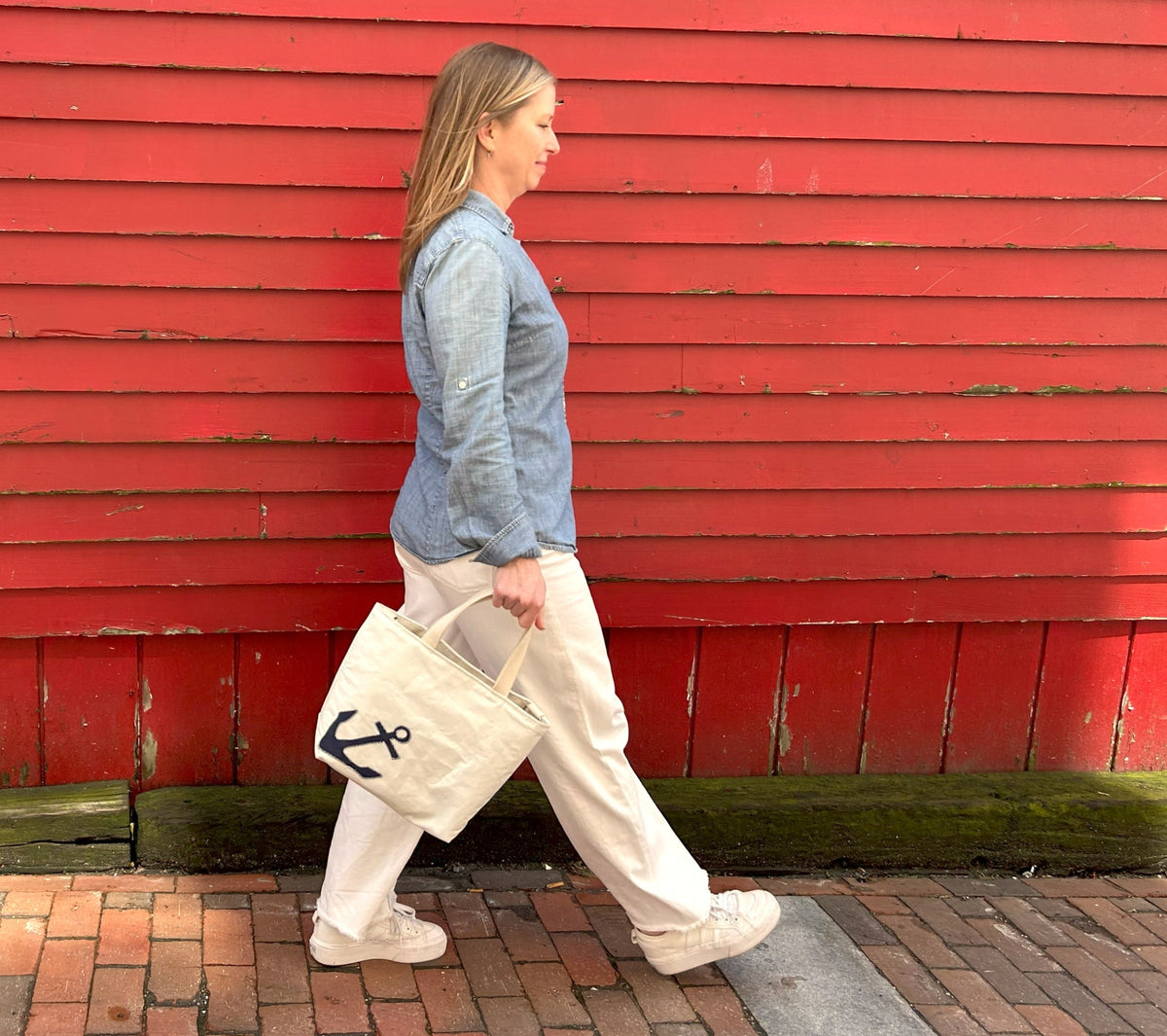 Person walking with cool crossbody tote, anchor design