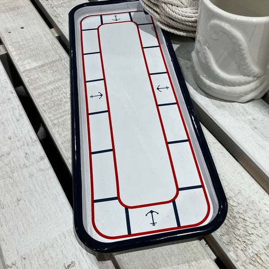 Enamel Anchor Serving Tray, a rectangular enameled metal tray with a white center, red and blue borders, and anchor icons at each end, adding a touch of coastal charm.
