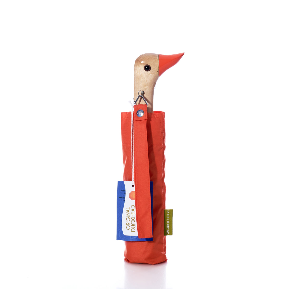 The Original Duck Head Umbrella - Papaya by ODH Limited t/a Original Duckhead features a wooden handle crafted in the shape of a duck’s head. This recycled, wind-resistant umbrella comes with a matching papaya-colored cover with attached tags and is shown standing upright on a white background, offering both durability and style for any weather.