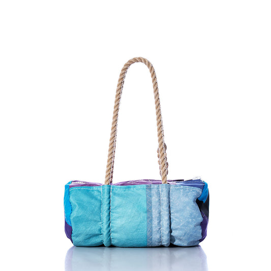 The Vintage Blue and Purple Baguette Bag by Sea Bags is crafted from recycled sails, features a textured surface, and is designed with two thick hand-spliced hemp rope handles. It is displayed on a white background. by Sea Bags