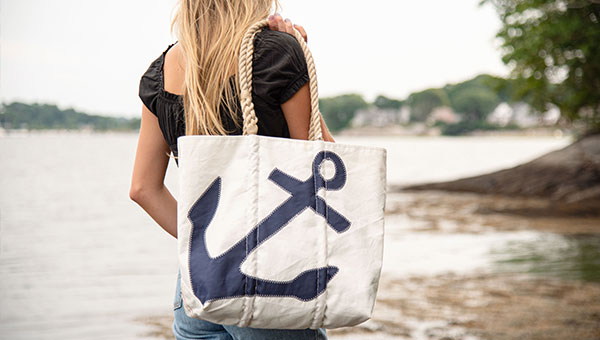 Model carrying Navy Anchor Tote overlooking water