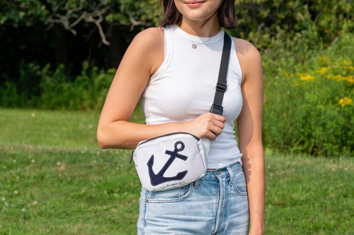 belt or sling bag, aka waist or fanny pack, worn by woman in a crossbody fashion, with anchor design