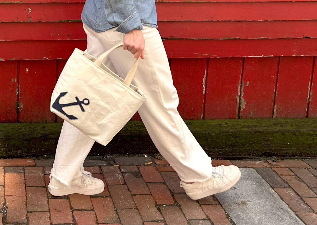 Person walking with cool crossbody tote, anchor design
