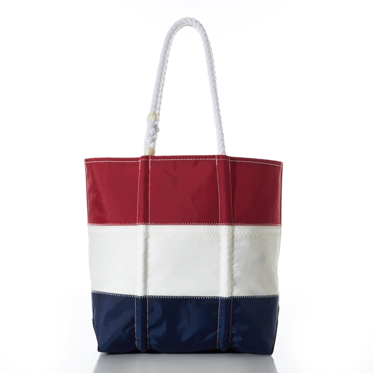 Introducing the Sea Bags Red White and Navy Stripe Medium Tote, crafted from recycled sail cloth as part of our Anniversary Archive Collection. This tote features horizontal panels in red, white, and navy blue, and is finished with two sturdy white rope handles. Shown on a white background.