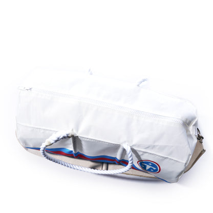 The Tennessee Titans Duffel by Sea Bags is a white duffel bag made from recycled sail cloth, featuring sturdy rope handles, a top zipper, and a small blue, red, and white patch near the bottom. Durable and stylish, this official NFL merchandise is perfect for Titans fans looking for something unique.