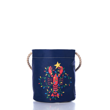 Crafted from recycled sail cloth, the Sea Bags Lobster Lights Bucket Bag features navy blue fabric, rope handles, and a festive red lobster adorned with Christmas lights and topped with a yellow star—a perfect tribute to New Englands maritime holiday traditions. by Sea Bags