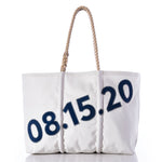 Sea Bags’ Custom Date Tote is a white tote bag with rope handles, showcasing the date 08.15.20 in bold blue numbers on the front—a perfect way to mark special occasions. Personalize your Sea Bags Custom Date Tote further by adding a custom message patch to create a truly unique keepsake. by Sea Bags
