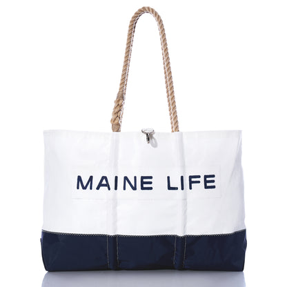 The Sea Bags Maine Life Large Tote is a spacious white and navy bag featuring sturdy rope handles and MAINE LIFE printed on the front, photographed against a white background. Inspired by Erin Ovalle’s signature Maine Life collection, this tote is perfect for everyday adventures. by Sea Bags