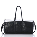 Black and white handbag with braided handle on a white background