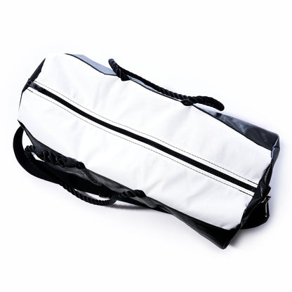The Sea Bags Black Dragon Duffel, made from water-resistant recycled sail cloth and featuring a zipper closure with black carrying straps, is shown in black and white on a white background. by Sea Bags