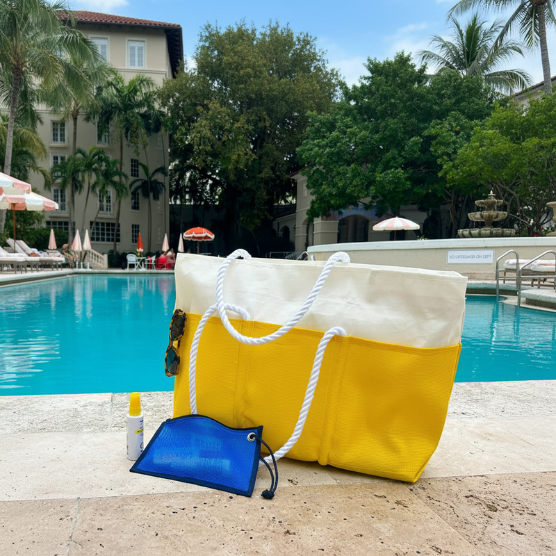 Yellow and white tote bag with rope handles by a poolside