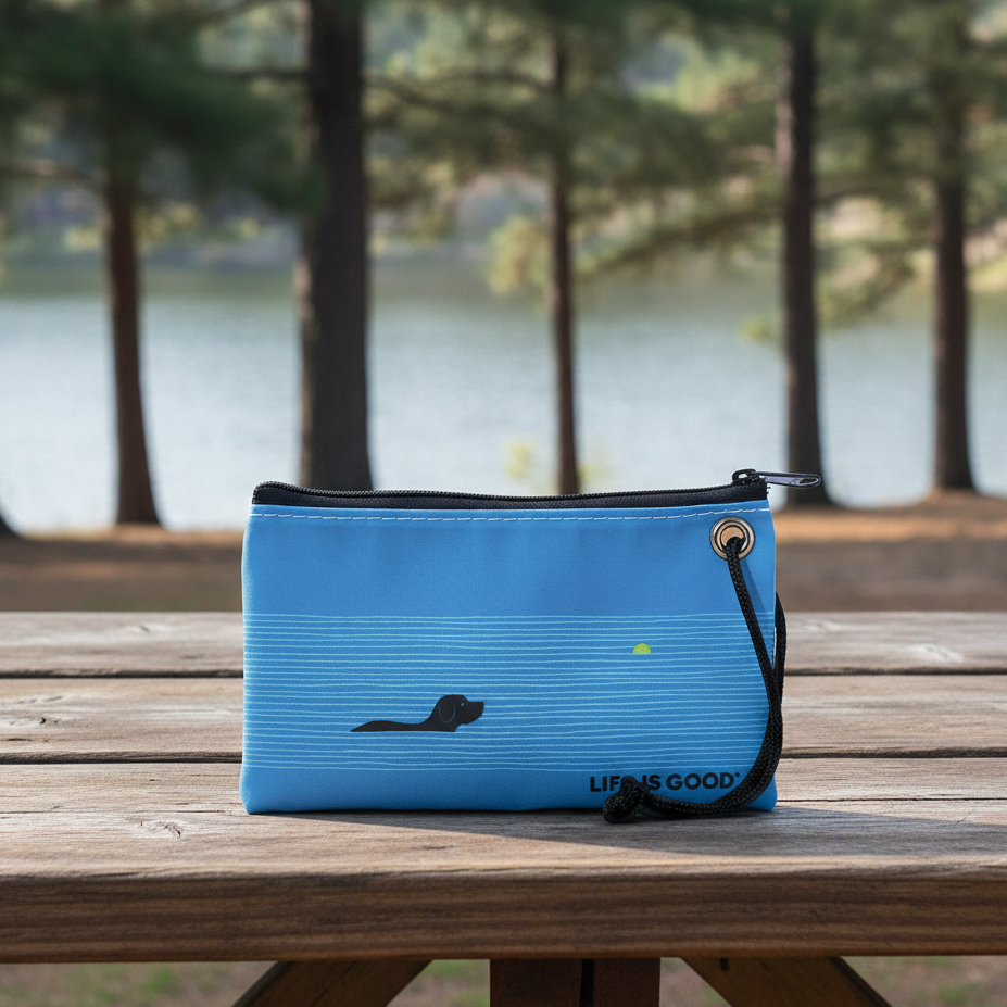 life is good dog days wristlet, blue clutch on picnic table at a lakeside park