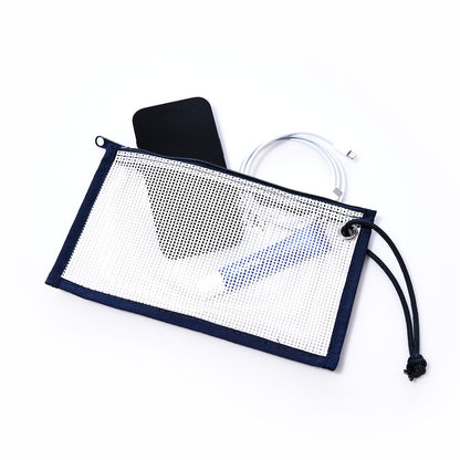 A Sea Bags Mesh Tote Organizer Pouch containing a black smartphone, a coiled charging cable, and a cylindrical object is displayed on a white background. by Sea Bags