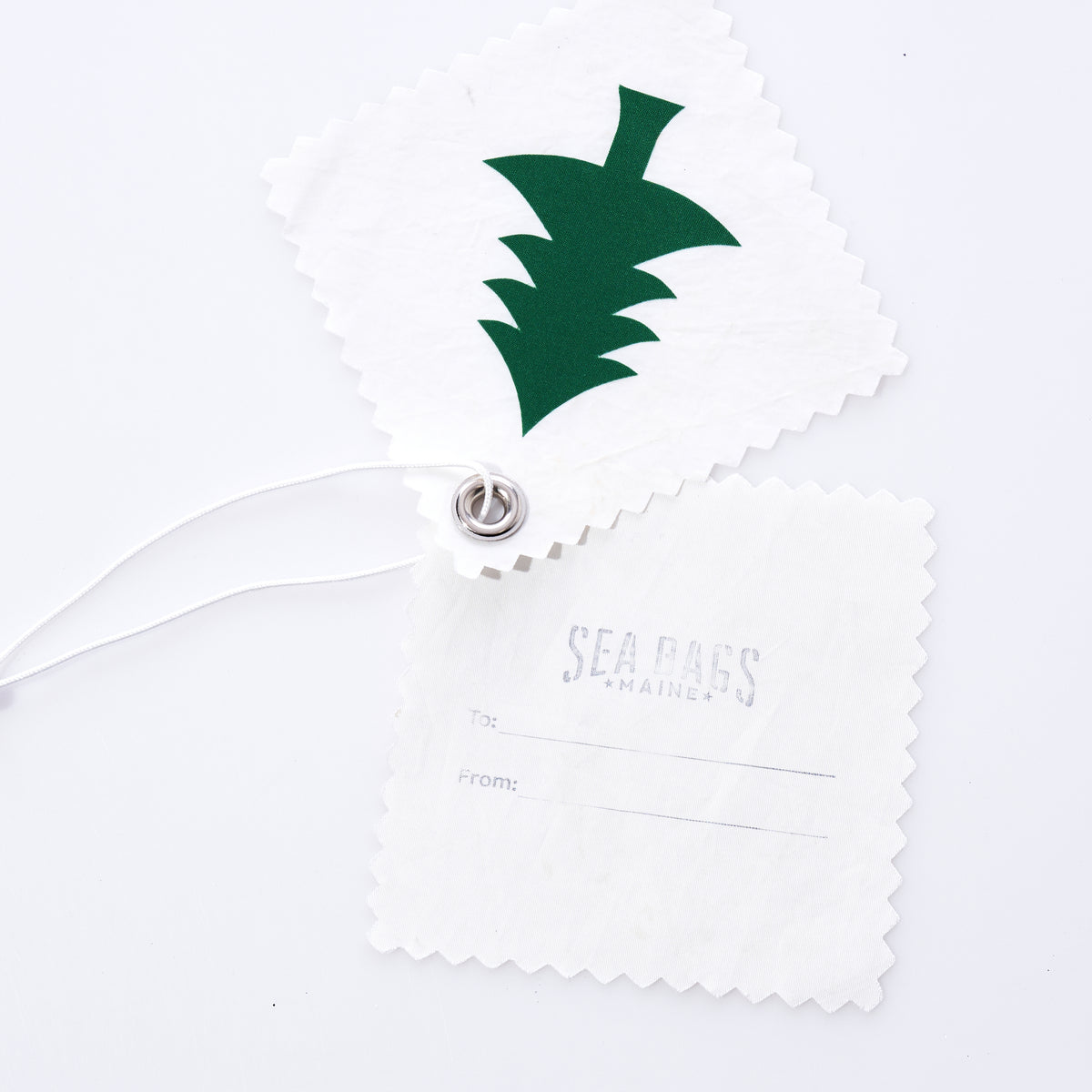 Two square Sail Cloth Gift Tag - Pack of 5 - Pine Tree tags with pinked edges made from recycled sail, one showing a green pine tree graphic and the other printed with “To:” and “From:” lines.