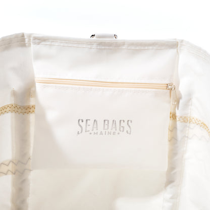 The U.S. Yacht Ensign Wharf Tote by Sea Bags features an interior crafted from recycled sail cloth, a zippered pocket embossed with SEA BAGS MAINE, and visible stitching along the seams, highlighting sustainable craftsmanship and timeless nautical style. by Sea Bags