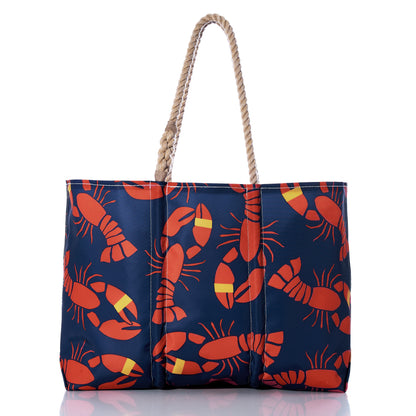 Introducing the Sea Bags Lobster Bake Large Tote: a navy blue maritime tote made from recycled sail cloth, adorned with red lobsters and yellow-striped lobster claws in a repeating pattern, and finished with classic rope handles—an ideal companion for any coastal adventure. by Sea Bags