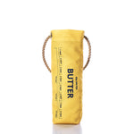 The Butter Wine Bag by Sea Bags, crafted from recycled sail cloth and featuring rope handles, measurement markings, and a SEA SALTED BUTTER label in yellow insulation, stands upright on a white background—an ideal wine bag for your next lobster bake. by Sea Bags