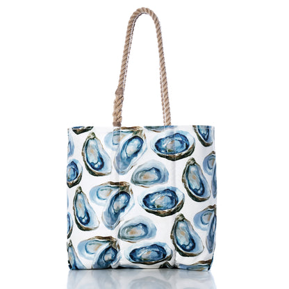 Introducing the Watercolor Oyster Medium Tote by Sea Bags—a white tote adorned with a blue and green oyster shell pattern evocative of watercolor artistry. Crafted from recycled sail cloth, this coastal beach tote is finished with two thick twisted rope handles, and is displayed here against a plain white background. by Sea Bags