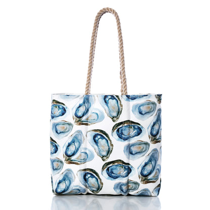 Sea Bags Watercolor Oyster Medium Tote features rope handles and a striking blue and green watercolor oyster shell pattern on a white background. This coastal beach tote is ideal for seaside adventures, capturing the easy charm of a watercolor oyster design. by Sea Bags