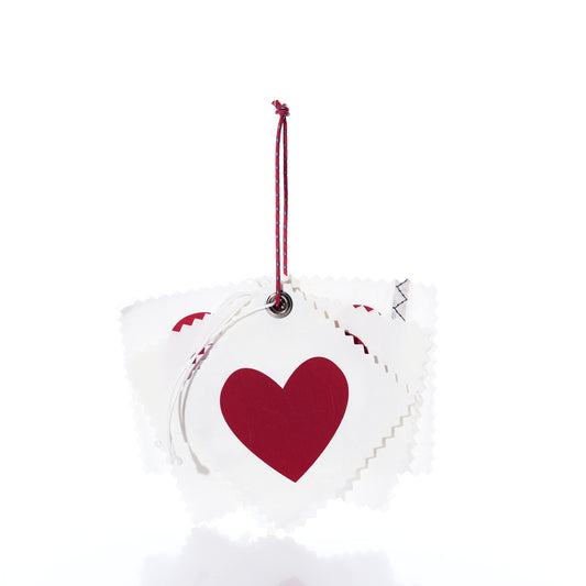 A stack of five heart-shaped Sea Bags Sail Cloth Gift Tag - Pack of 5 - Heart featuring red hearts and red and white cord loops.