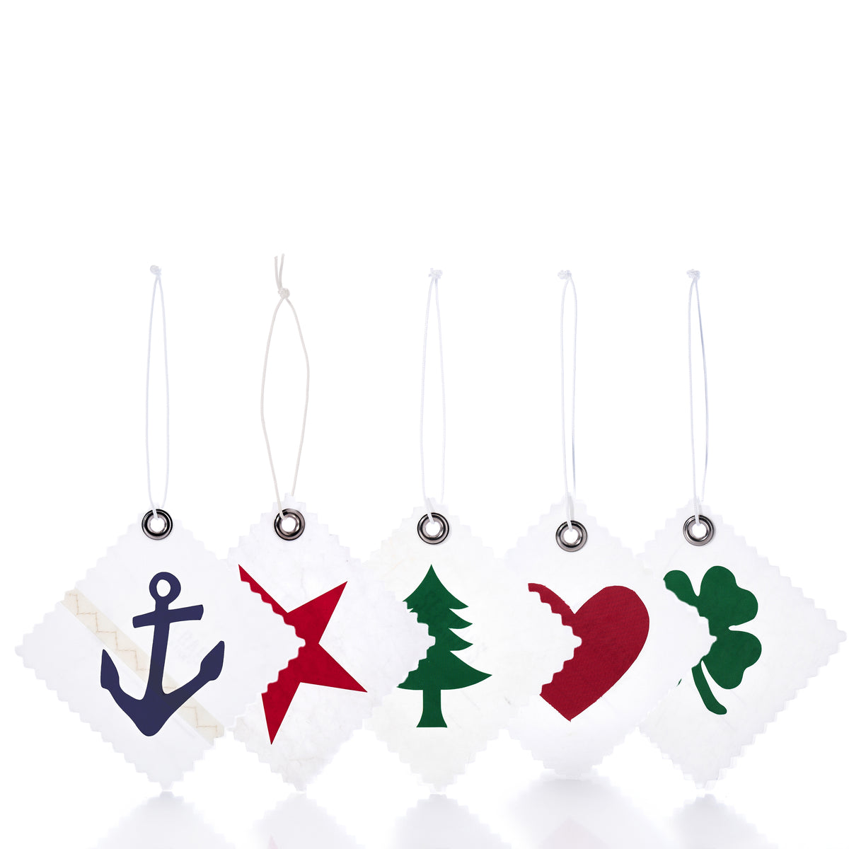 A pack of five square, white recycled Sea Bags Sail Cloth Gift Tag - Pack of 5 - Multi featuring jagged edges and cutouts or prints of an anchor, star, pine tree, heart, and shamrock.