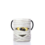 The Sea Bags Happy Mummy Bucket Bag is crafted from white recycled fabric and features yellow cartoon eyes, black rope handles, and a playful mummy-inspired design, shown on a white background. by Sea Bags