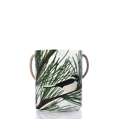 Maine Chickadee Bucket: a cylindrical recycled sailcloth bag with rope handles, featuring a chickadee perched on a pine branch for coastal holiday decor.
