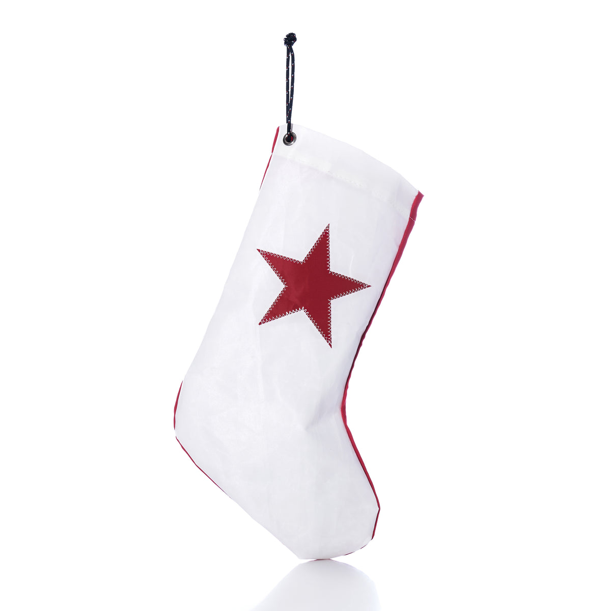 A white Red Star Stocking with a red star and red trim, hanging from a black cord as sustainable holiday decor.