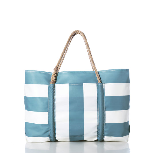 The Sea Bags Denim Blue Trolley Sleeve Travel Pier Tote features blue and white stripes, tan rope handles, and a convenient trolley sleeve, shown against a white background. by Sea Bags