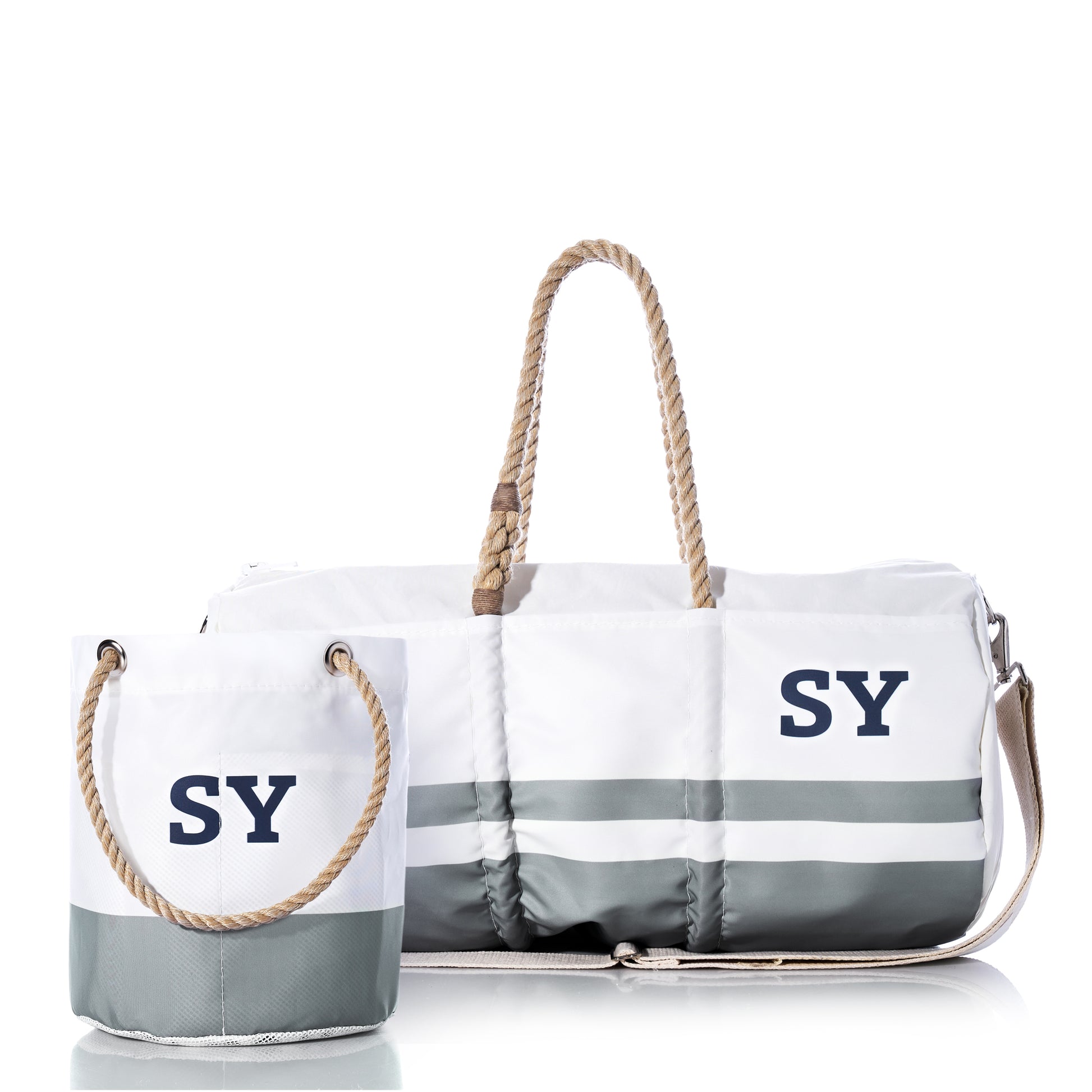 Custom Monogram Breton Stripe Duffel and Bucket Bundle from Sea Bags features a spacious tote and a compact bucket bag, both crafted from recycled sailcloth with white and gray stripes, rope handles, and your choice of monogram displayed on the front against a white background.