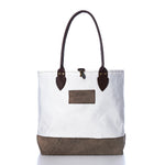 Heritage Ticonderoga Medium Tote made from white vintage sail cloth, featuring brown leather handles, a brown base, and a brown rectangular patch on the front.