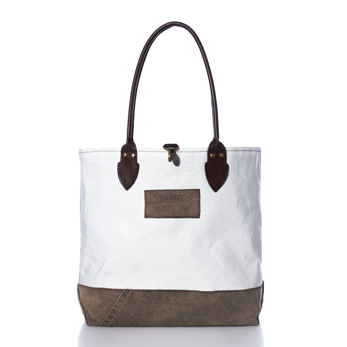 Heritage Ticonderoga Medium Tote made from white vintage sail cloth, featuring brown leather handles, a brown base, and a brown rectangular patch on the front.