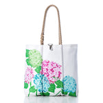 2026 Hope In Bloom Medium Tote with Clasp made of white sailcloth with rope handles, a metal clasp closure, and a green, pink, and blue hydrangea print.