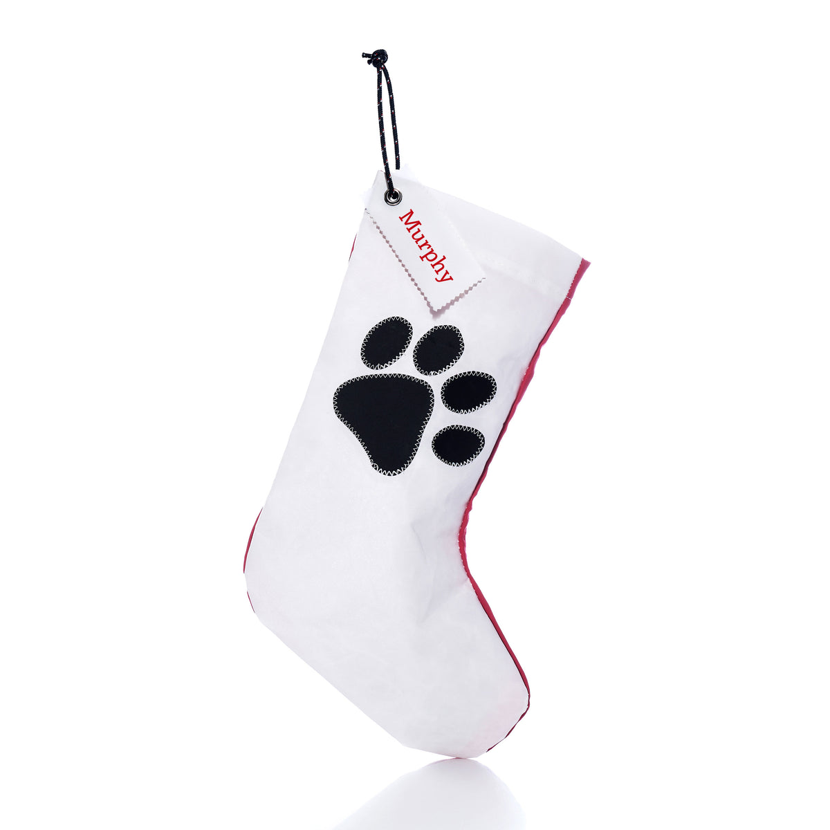 Sea Bags Paw Print Stocking with Personalized Sail Cloth Tag in white recycled sailcloth, featuring a black paw print and a tag personalized with the name “Murphy.”