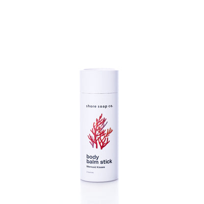A white cylindrical push-up tube of Mermaid Kisses Eco-Friendly Body Balm featuring a red coral illustration and black text.