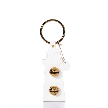 White Lighthouse Door Chime by New England Bells, crafted in the shape of a lighthouse with two gold-colored knobs and a round metal keyring, reminiscent of their iconic handcrafted designs, photographed on a white background.