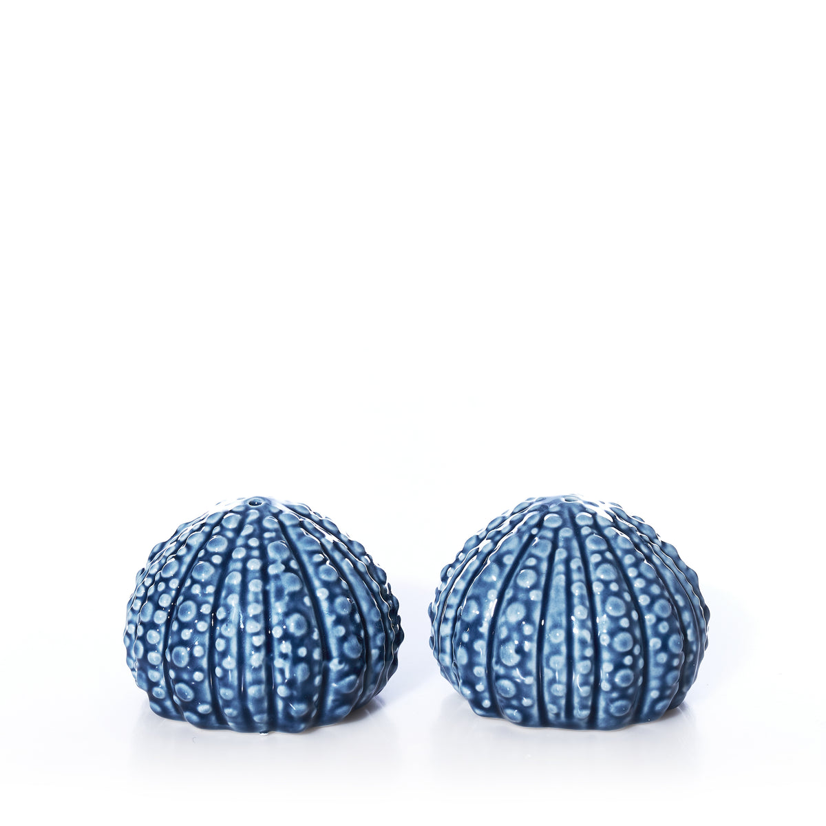 Two blue, textured ceramic Batela - Sea Urchin Salt  Pepper Shaker Set pieces for coastal table decor.