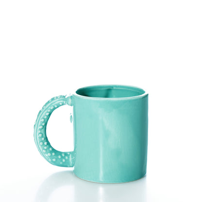 A Starfish Mug by Batela USA Inc, featuring a turquoise ceramic design and a sea-star textured handle, sits on a white background.