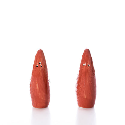 The Lobster Claw Salt  Pepper Shaker Set by Batela USA Inc features two vibrant red ceramic shakers, each with three holes and a playful claw design, standing upright on a white background—perfect for bringing bold color and coastal charm to your seaside kitchen décor.