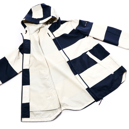 The Batela USA Inc Harborside Waterproof Raincoat in Stripe Navy  White features a white waterproof shell with bold navy blue horizontal stripes, a hood, front zipper, and large flap pockets, and is displayed on a white background.