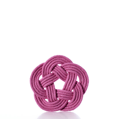 A pink rope knotted into a flat, decorative shape is displayed against a white background, reminiscent of the Nautical Sailor Knot Coaster Set of 4 in Pink by Mystic Knotwork, handmade in the USA from soft cotton.