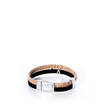 The Classic Cork Bracelet - Shark on Black by Elisabetta Studio features brown and black Portuguese cork with an antique silver shark magnetic clasp engraved with the brand name, shown against a white background. by Sea Bags
