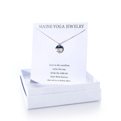 Horizon Silver pendant necklace by Maine Yoga Jewelry, featuring a round silver pendant displayed on a card with a Ralph Waldo Emerson quote, elegantly presented in a white jewelry box—an exquisite addition to any jewelry collection. by Sea Bags