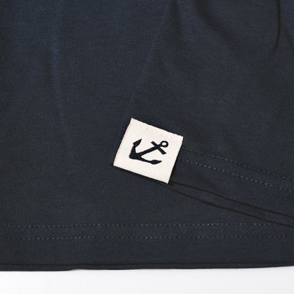 Dark blue Sea Bags Sailing Team T-Shirt hem with a square white patch featuring a black anchor logo.