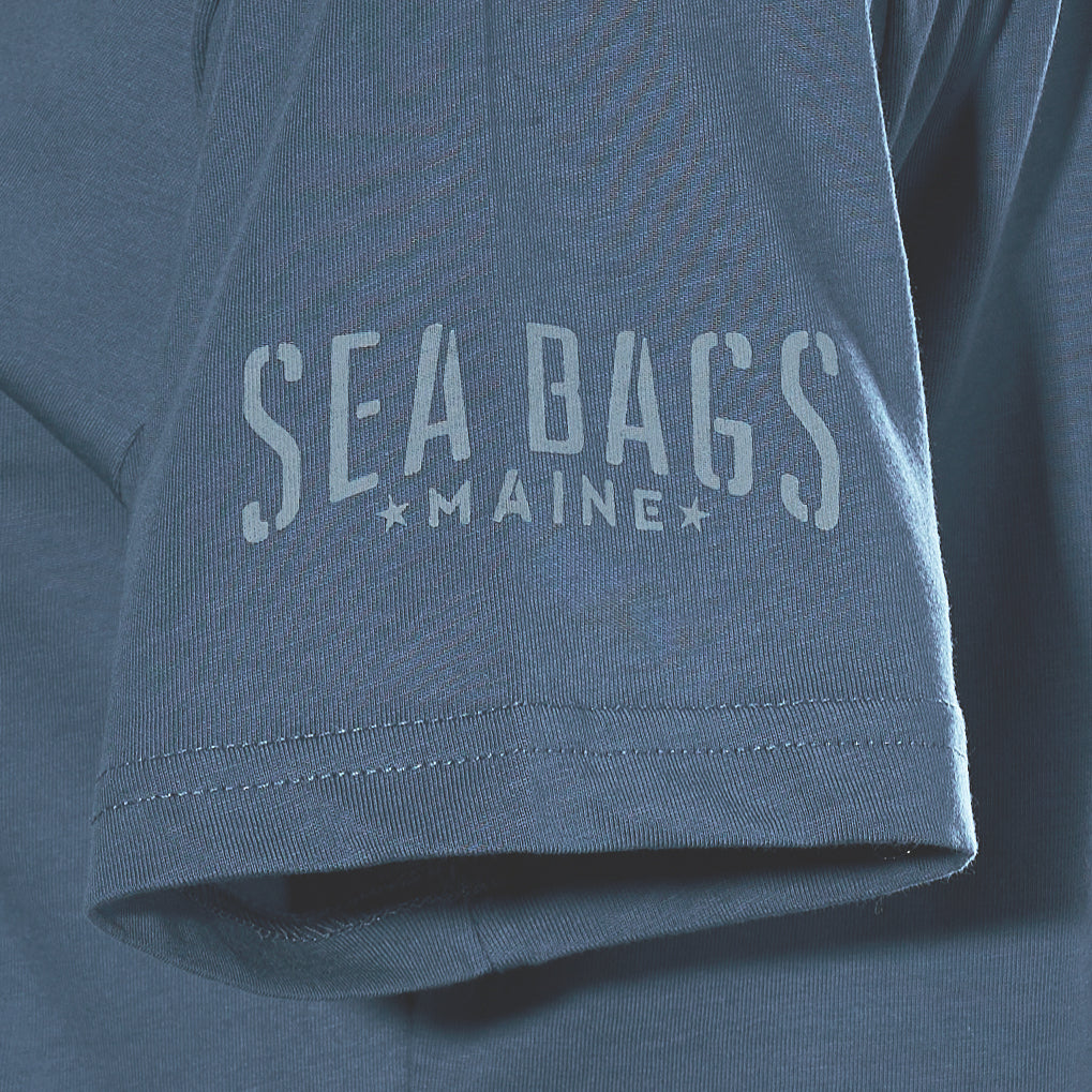 Close-up of a blue Sea Bags 06 Octopus T-Shirt sleeve by 320Ink d/b/a Riptide Print Company, featuring “SEA BAGS MAINE” in light letters.