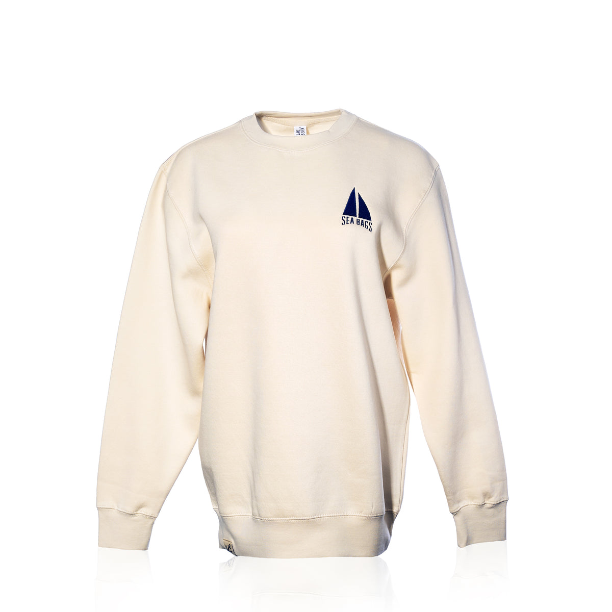 Cream-colored Sailboat Crewneck Sweatshirt featuring an embroidered navy blue sailboat icon and “SEA BAGS” text on the left chest.