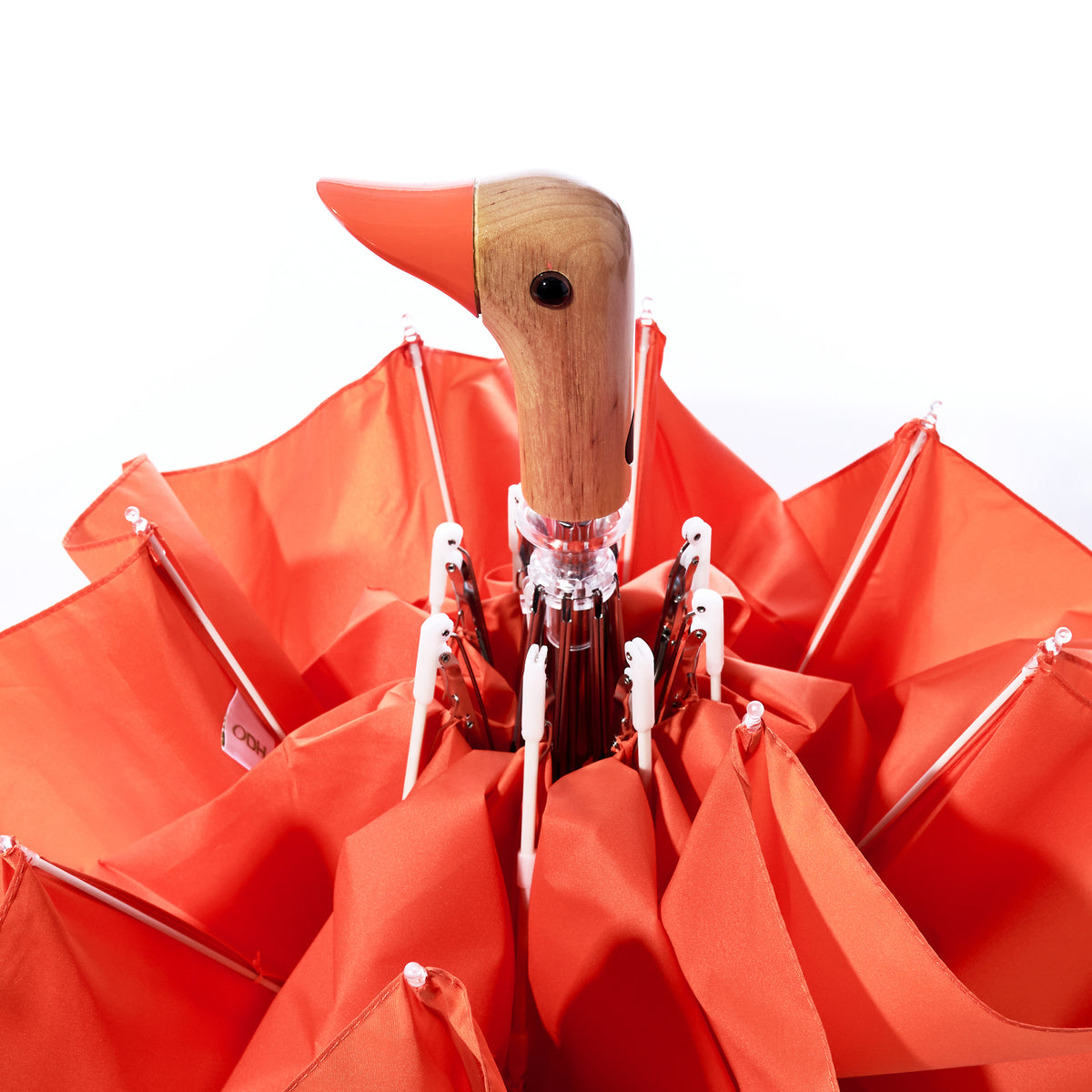 An Original Duck Head Umbrella - Papaya by ODH Limited t/a Original Duckhead, crafted from recycled umbrella materials and featuring a duck head-shaped handle, is shown closed against a white background.