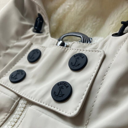 Close-up of the Harborside Waterproof Fleece-Lined Raincoat - Moonstruck by Batela USA Inc, with four black anchor buttons, visible faux fur lining, and a partially shown white zipper.