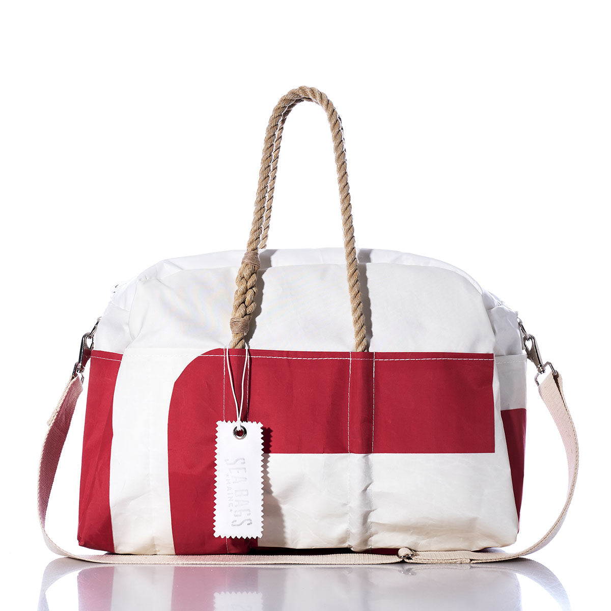 The Sea Bags Vintage Red and White Weekender is displayed on a white background, featuring rope handles, a detachable shoulder strap, and a SCOUTS tag hanging from one handle. by Sea Bags