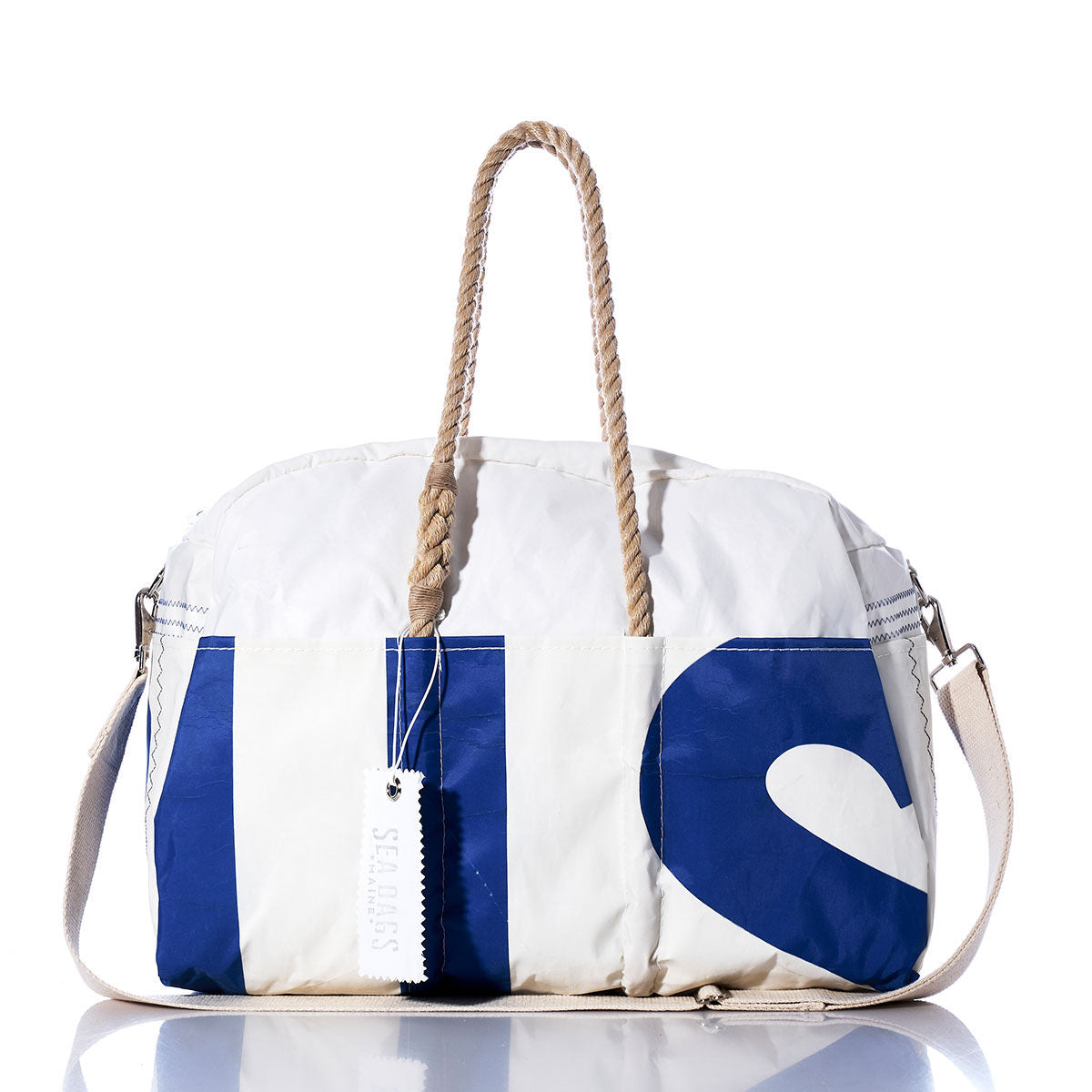 Introducing the Vintage US Weekender by Sea Bags—a vintage-inspired white duffle bag featuring blue lettering, sturdy rope handles, a beige shoulder strap, and a signature Sea Bags tag. It’s the perfect go-to weekender bag for any getaway. by Sea Bags